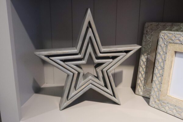 Set of three grey wooden stars inside one another with a distressed finish