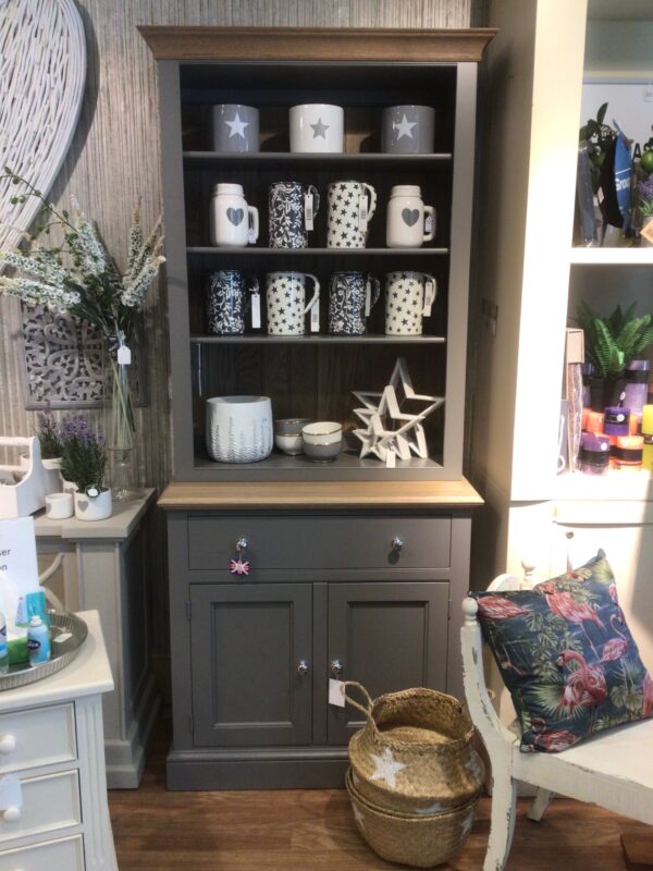 Grey dresser with open shelving. Styled on the open shelving are various enamel jugs styled on open shelving. Grey with white floral design. White with grey star motif. White with grey heart mason style jug. Set of three white stars.